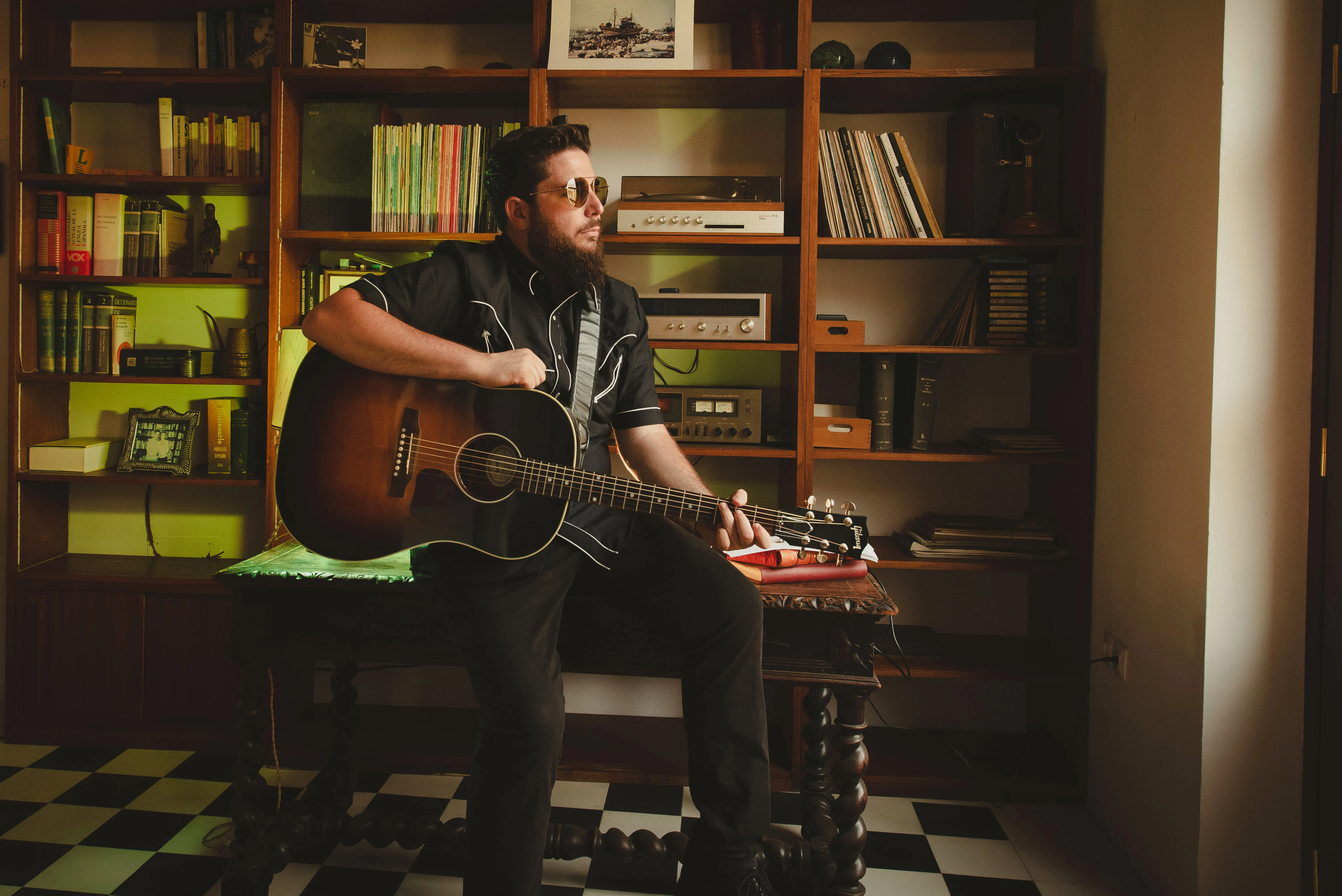 JJ Fuentes con guitarra acústica, interior